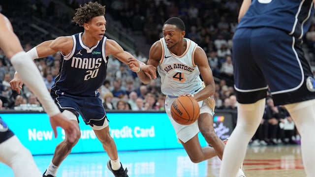 Mar 12, 2025; San Antonio, Texas, USA; San Antonio Spurs guard De&#39;Aaron Fox (4) dribbles against Dallas Mavericks forward Kessler Edwards (20) in the first half at Frost Bank Center. Mandatory Credit: Daniel Dunn-Imagn Images
