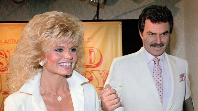 FILE - Burt Reynolds, right, holds hands with Loni Anderson at a luncheon, March 27, 1987, in Los Angeles.