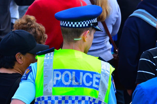 A New Zealand police officer walks in a crowd of people. 