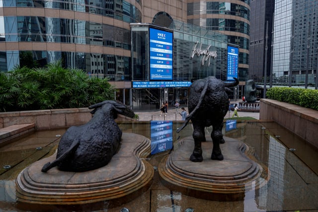 FILE PHOTO: Bull statues are placed in font of screens showing the Hang Seng stock index and stock prices outside Exchange Square, in Hong Kong, China, August 18, 2023. REUTERS/Tyrone Siu/File Photo/File Photo