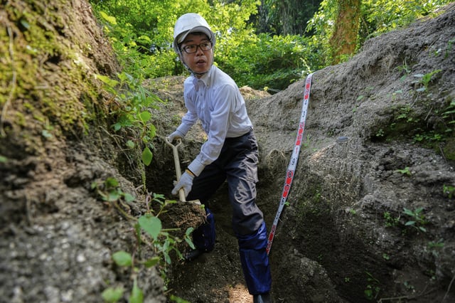 Rebun Kayo, a Hiroshima University researcher, searches for remains of victims of the 1945 Hiroshima bombing in Ninoshima in Hiroshima, western Japan, Tuesday, July 8, 2025. (AP Photo/Eugene Hoshiko)