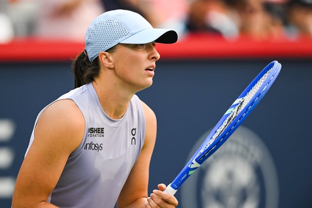 Aug 3, 2025; Montreal, QC, Canada; Iga Swiatek (POL) waits for Clara Tauson (DEN) to serve the ball in fourth round play at IGA Stadium. Mandatory Credit: David Kirouac-Imagn Images
