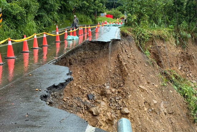 Photo fournie par les pompiers de Kaohsiung montrant un glissement de terrain ayant emporté une portion de route dans une zone montagneuse de Kaohsiung sur l'île de Taïwan le 3 août 2025.