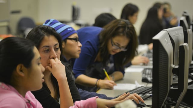 A volunteer closely reads a college essay of high school students at a program that helps undocumented immigrants write college essays and scholarship applications in Arlington, Va., in 2014. Photo: Jahi Chikwendiu/The Washington Post via Getty Images