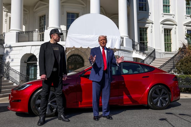 U.S. President Donald Trump talks to the media next to Tesla CEO Elon Musk, at the White House in Washington, D.C., U.S., March 11, 2025. REUTERS/Kevin Lamarque/File Photo