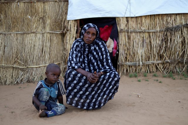Houda Ali Mohammed, 32, a displaced Sudanese mother of four, looks on next to her child inside a camp shelter amid the ongoing conflict between the paramilitary Rapid Support Forces (RSF) and the Sudanese army, in Tawila, North Darfur, Sudan, July 30, 2025. REUTERS/Mohamed Jamal