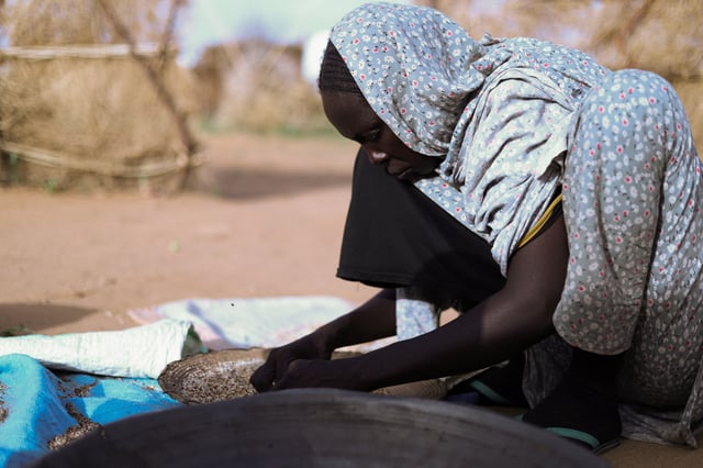 Hanan Adam Hassan, 39, a displaced Sudanese mother of five, including her child Enaam, prepares food at a camp shelter amid the ongoing conflict between the paramilitary Rapid Support Forces (RSF) and the Sudanese army, in Tawila, North Darfur, Sudan, July 30, 2025. REUTERS/Mohamed Jamal