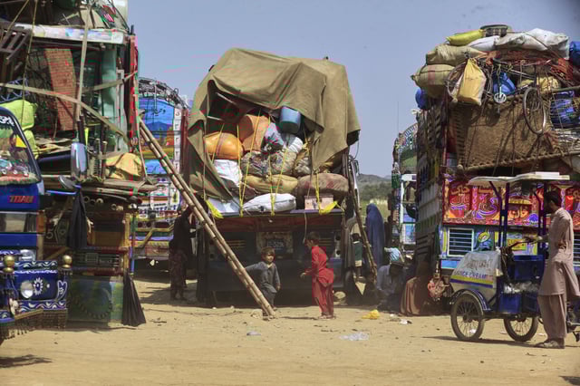 FILE - Afghan refugee children play next to trucks loaded with their family's belongings as they wait to return Afghanistan along a highway in Landi Kotal, Pakistan, April 9, 2025. (AP Photo/Muhammad Sajjad, File)