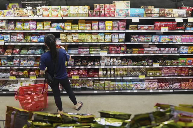 FILE - A customer buys Chinese made ginger candy at 99 Ranch Market, an Asian grocery store in Los Angeles, April 7, 2025. (AP Photo/Damian Dovarganes, File)