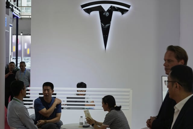 Visitors at the Tesla booth during the 3rd China International Supply Chain Expo at the China International Exhibition Center, in Beijing, China, Friday, July 18, 2025. (AP Photo/Mahesh Kumar A.)