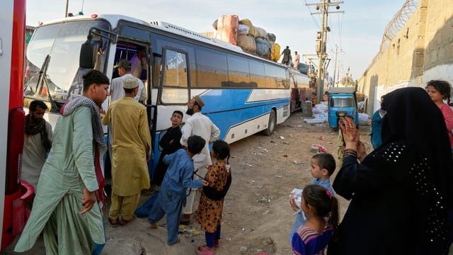 Afghan refugees board a bus to leave for their homeland Afghanistan, at a terminal in Karachi, Pakistan, on April 9.