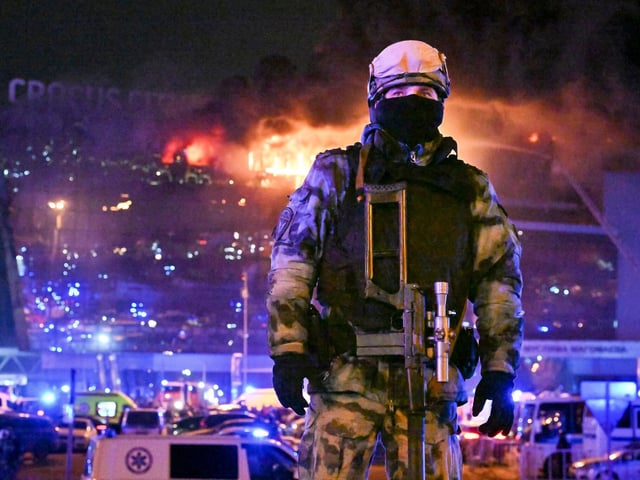 Eine Einsatzkraft vor der brennenden Konzerthalle in Moskau.