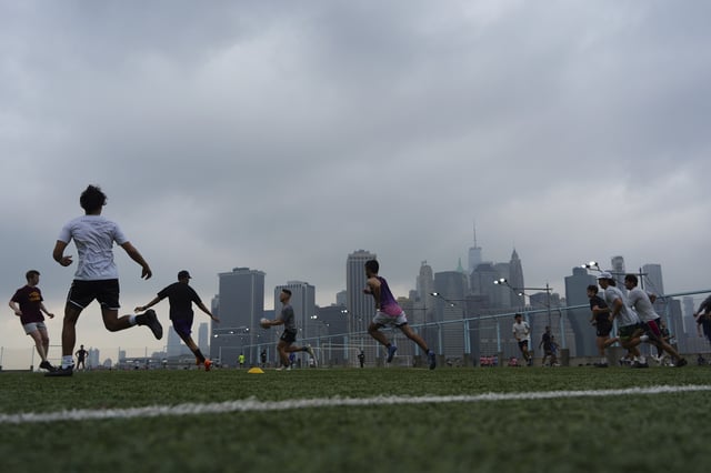 NEW YORK, NY - JULY 27: People play rugby in the hazy weather at Brooklyn Bridge Park on July 27, 2025 in New York City. An air quality health advisory has been issued for New York City and its surrounding areas because of smoke from wildfires in Canada. (Photo by Liao Pan/China News Service/VCG via AP )