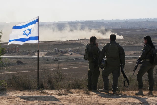 Israeli soldiers watch the northern Gaza Strip from southern Israel, Wednesday, July 30, 2025. (AP Photo/Ohad Zwigenberg)