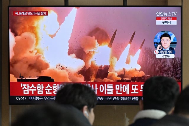 People stand near a television showing a news broadcast with file footage of a North Korean missile test, at a railway station in Seoul on March 14, 2023. - North Korea fired two short-range ballistic missiles on March 14, 2023, Seoul said, Pyongyang's second launch in three days and the first since South Korea and the United States began their largest joint military drills in five years. (Photo by Anthony WALLACE / AFP) (Photo by ANTHONY WALLACE/AFP via Getty Images)