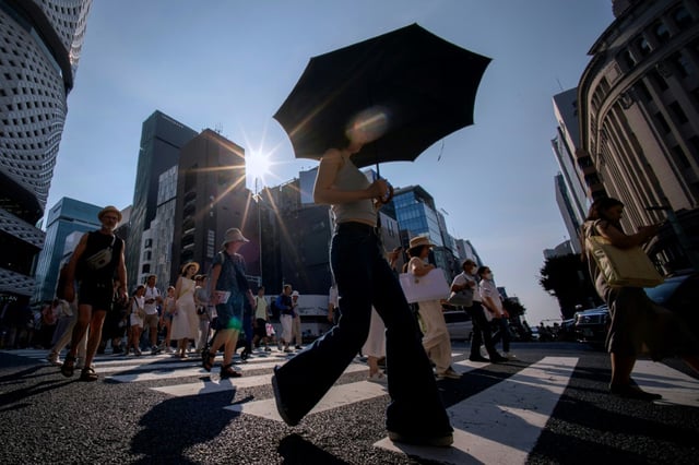 Des passants traversent la rue à Tokyo, au Japon, en pleine vague de chaleur, le 4 août 2025