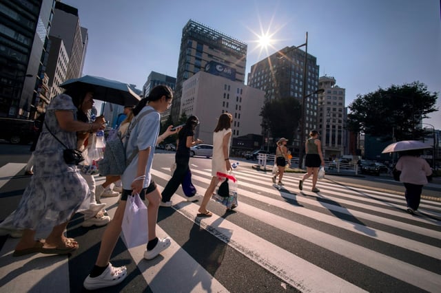 Des passants traversent la rue à Tokyo, au Japon, en pleine vague de chaleur, le 4 août 2025