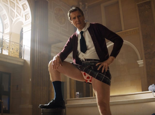 Liam Neeson, a big man in little girl disguise, is the new Lt. Frank Drebin in “The Naked Gun.” (Paramount Pictures)