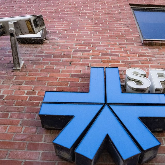 A surveillance camera is seen beside an SPVM logo on a detention centre in Montreal, Thursday, Aug. 29, 2024. THE CANADIAN PRESS/Christinne Muschi