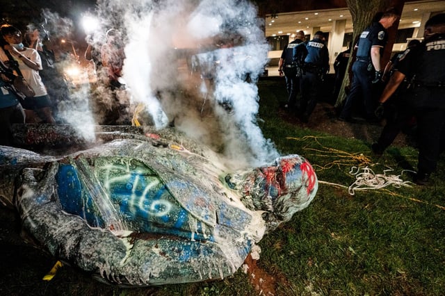 Police extinguish the burning statue of Confederate General Albert Pike near Judiciary Square in Washington, D.C., on June 19, 2020.