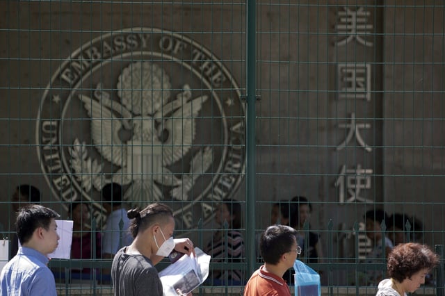 FILE - In this July 26, 2018 file photo visa applicants wait to enter the U.S. Embassy in Beijing, China. (AP Photo/Ng Han Guan, File)