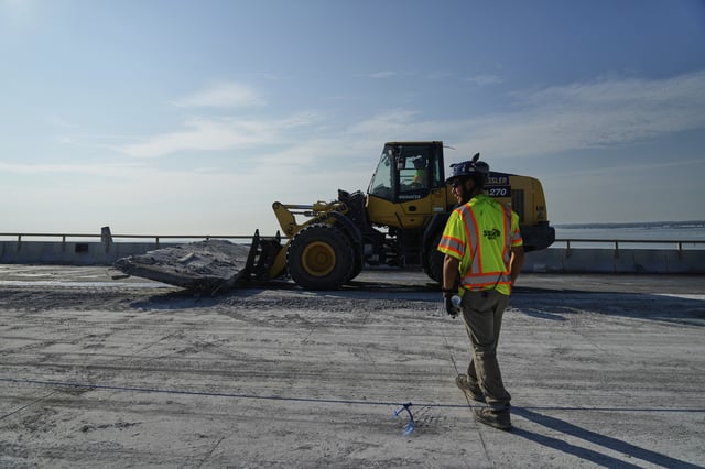 A demolition crew removes a slab of concrete from the remaining portions of the Francis Scott Key Bridge, Wednesday, July 30, 2025, in Baltimore. (AP Photo/Stephanie Scarbrough)