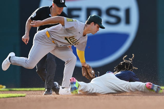 Jul 18, 2025; Cleveland, Ohio, USA; Athletics second baseman Max Muncy (10) tags out Cleveland Guardians third baseman Jose Ramirez (11) on a steal attempt during the first inning at Progressive Field. Mandatory Credit: Ken Blaze-Imagn Images/File Photo