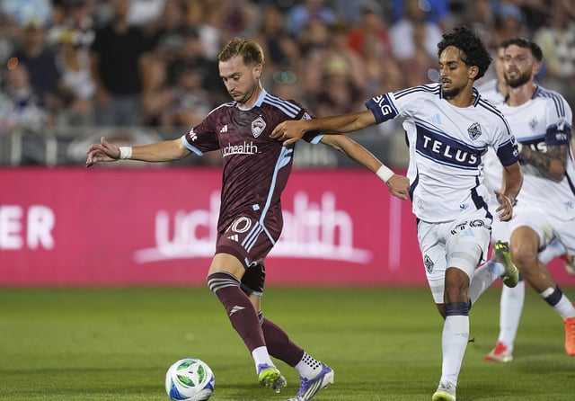 Colorado Rapids midfielder Djordje Mihailović, left, moves past Vancouver Whitecaps midfielder Jeevan Badwal in the second half of an MLS soccer match Saturday, July 12, 2025, in Commerce City, Colo. (AP Photo/David Zalubowski)