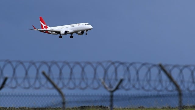A Qantas plane lands at Brisbane Airport (Image: AAP/Jono Searle)
