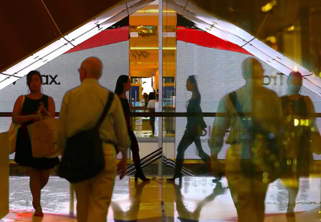 Shoppers are reflected in a window near retail stores at a shopping center in central Sydney, Australia April 18, 2017. Picture taken April 18, 2017. REUTERS/Steven Saphore/ File Photo