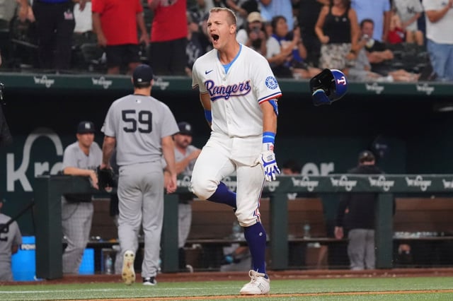 Texas Rangers&#39; Josh Jung, right, celebrates after his home run as New York Yankees pitcher Jake Bird (59) walks to the dugout during the 10th inning of a baseball game Monday, Aug. 4, 2025, in Arlington, Texas. (AP Photo/LM Otero)