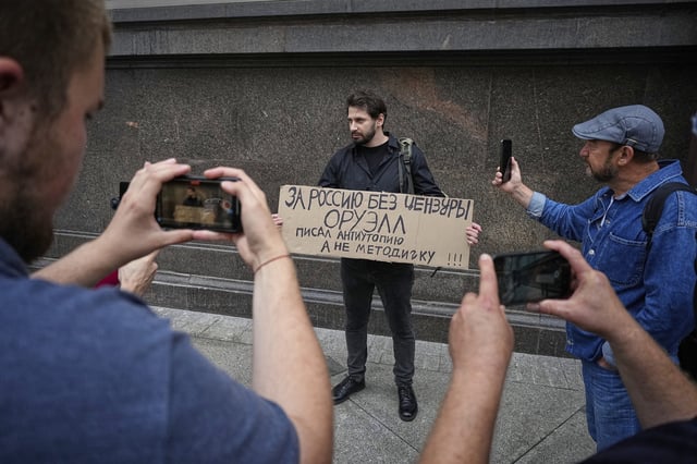 An activist holds a sign reading, "For Russia without censorship. Orwell wrote a dystopia, not an instruction manual,” referring to author George Orwell during a protest in front of the State Duma, the lower house of the Russian parliament, in Moscow, Russia, Tuesday, July 22, 2025, prior to lawmakers approving a measure that punishes online searches for information that is deemed “extremist.” (AP Photo)