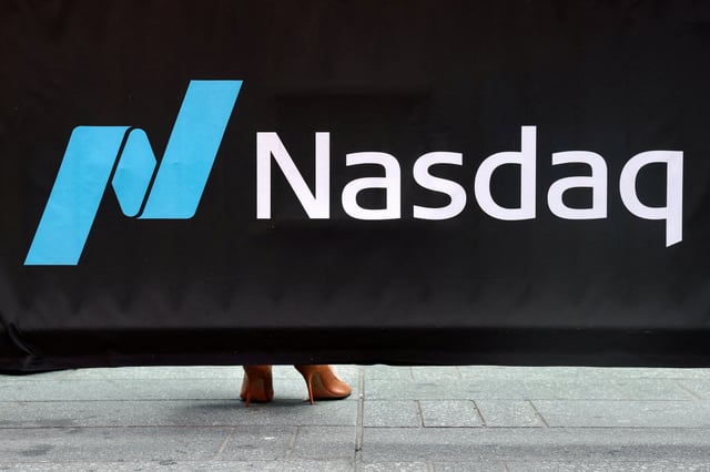 A person wearing high heels stands behind a Nasdaq banner in New York City, U.S., July 23, 2025. REUTERS/Kylie Cooper/File Photo