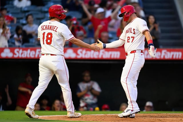 Los Angeles Angels’ Mike Trout, right, and Nolan Schanuel, left, greet each other after scoring during the third inning of a baseball game against the Tampa Bay Rays, Monday, Aug. 4, 2025, in Anaheim, Calif. (AP Photo/William Liang)