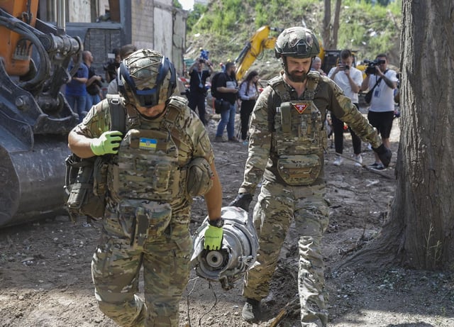 Expertos transportan una parte del cohete en el lugar de un ataque contra un edificio residencial de nueve plantas en Kiev.