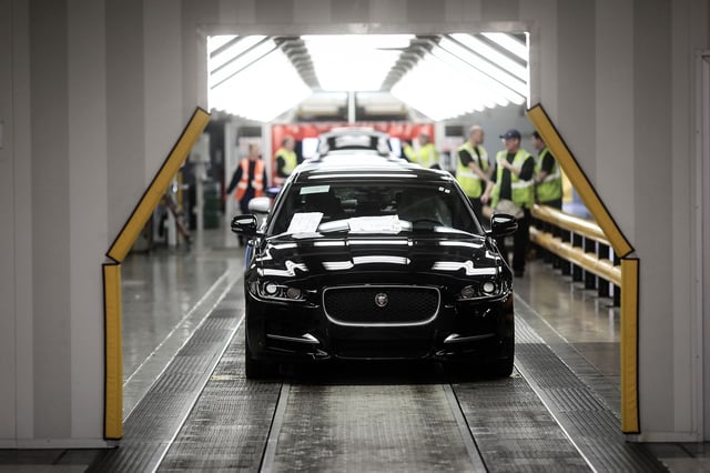 A finished Jaguar XJ automobile moves through the final inspection area on the production line.