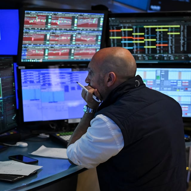 A trader works on the floor of the New York Stock Exchange (NYSE) during morning trading on August 4, 2025, in New York City.