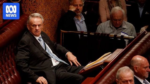 Mark Latham waits to be sworn into the NSW Parliament on a the chamber bench. 