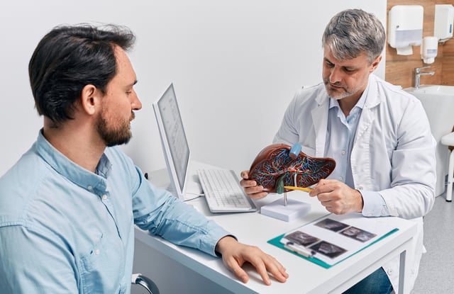 File photo: a gastroenterologist doctor explaining liver and gallbladder problems using an anatomical model to a patient during a clinic visit.