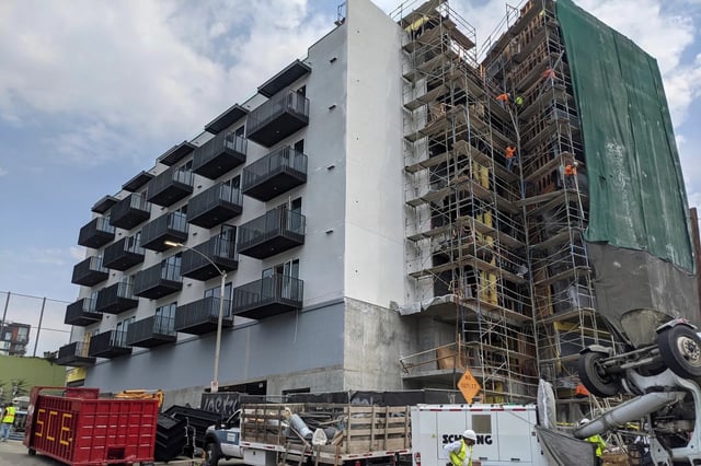 Construction workers finish the exterior of an apartment building in downtown Los Angeles on June 18, 2021. (Damian Dovarganes, AP Photo)