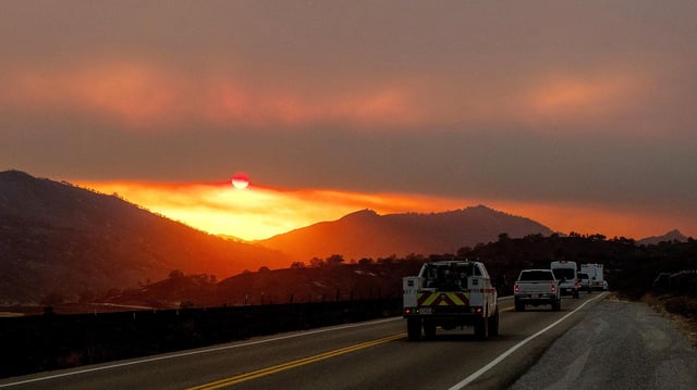 Die Sonne scheint durch Rauchschwaden über einer Straße im Los Padres National Forest