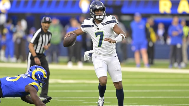 Jan 5, 2025; Inglewood, California, USA; Seattle Seahawks quarterback Geno Smith (7) scrambles away from Los Angeles Rams linebacker Byron Young (0) and throws for a touchdown in the first half at SoFi Stadium. Mandatory Credit: Jayne Kamin-Oncea-Imagn Images