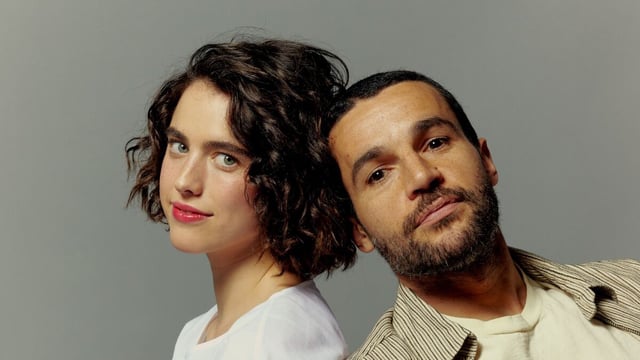 Actors Margaret Qualley and Christopher Abbott pose for a portrait, leaning against each other.