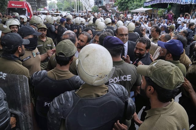 Police officers block supporters of Pakistan's imprisoned former Prime Minister Imran Khan's party for holding a protest marking second anniversary of Khan's incarceration, in Lahore, Pakistan, Tuesday, Aug. 5, 2025. (AP Photo/K.M. Chaudary)