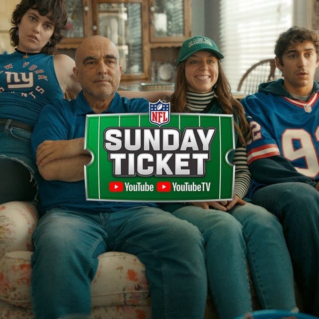 Family wearing football apparel sitting on couch