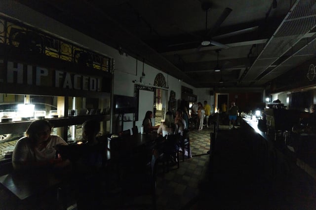 FILE - Customers sit inside a restaurant lit by battery-powered lanterns during an island-wide power outage, in Old San Juan, Puerto Rico, April 16, 2025. (AP Photo/Alejandro Granadillo, File)
