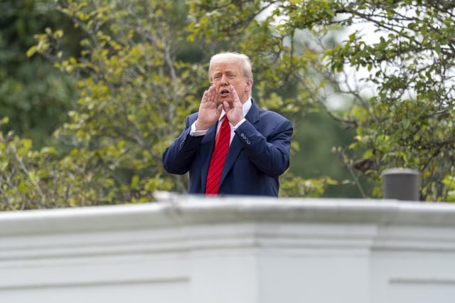 President Donald Trump shouts to reporters as he surveys the grounds from the roof above the Colonnade that goes to the West Wing of the White House, Tuesday, Aug. 5, 2025, in Washington. (AP Photo/Alex Brandon)
