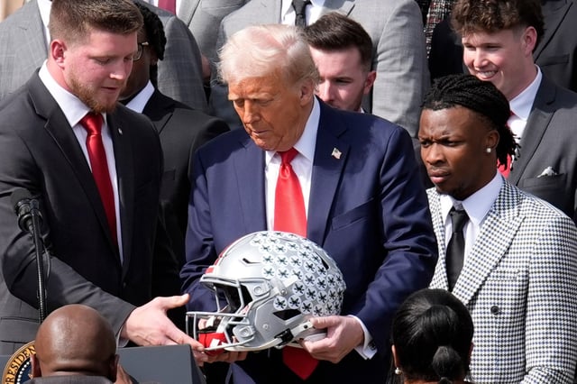 President Donald Trump is presented with an Ohio State helmet as he welcomes the national championship-winning Buckeyes to the White House earlier this year.  (Yuri Gripas/Abaca Press/TNS)