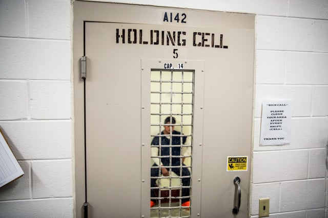 A detainee sits in a holding cell at the Stewart Detention Center, in Lumpkin, Ga., on Nov. 15, 2019.