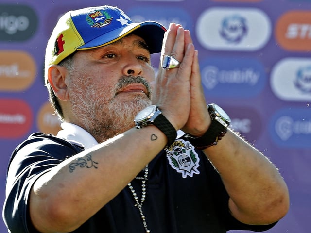 (FILES) In this file photo taken on November 02, 2019 Gimnasia y Esgrima team coach Diego Armando Maradona gestures to supporters as he leaves the field after an Argentina First Division Superliga football match against Estudiantes, at El Bosque stadium, in La Plata, Buenos Aires province, Argentina. - Genius, idol, magician, the synonyms used to talk about Diego Armando Maradona. The '10' that broke into Argentine soccer in the 70s harvested a legion of faithful that covered him in life and that keeps him in a seat of deity a year after his death. (Photo by ALEJANDRO PAGNI / AFP)